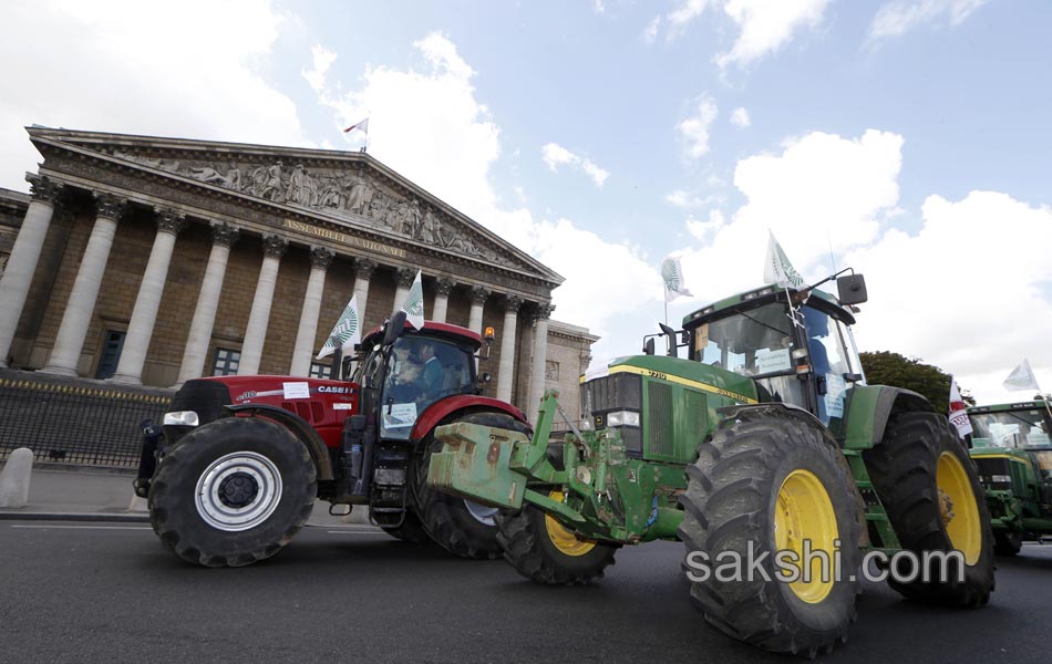 Tractors roll along a street in Paris8