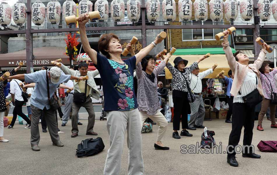 Elderly people work out with wooden dumb bells6