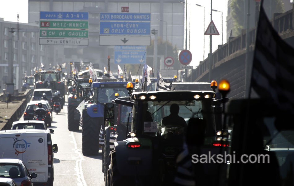 Tractors roll along a street in Paris18