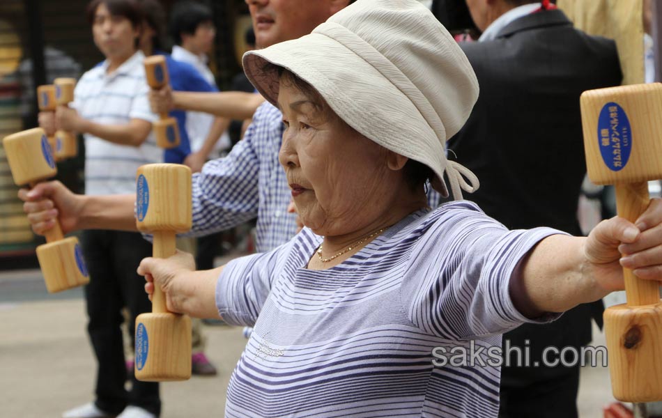 Elderly people work out with wooden dumb bells3