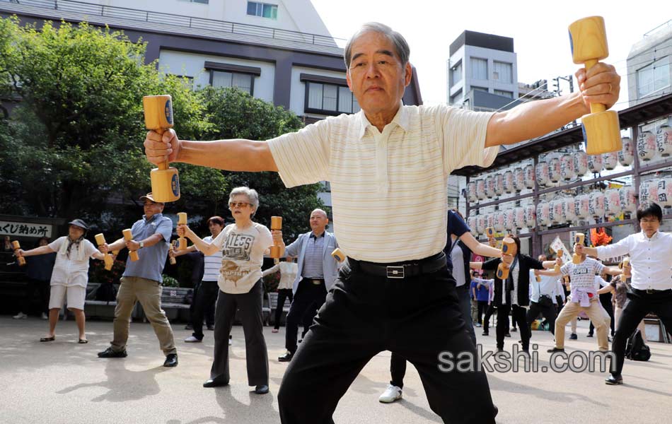 Elderly people work out with wooden dumb bells4