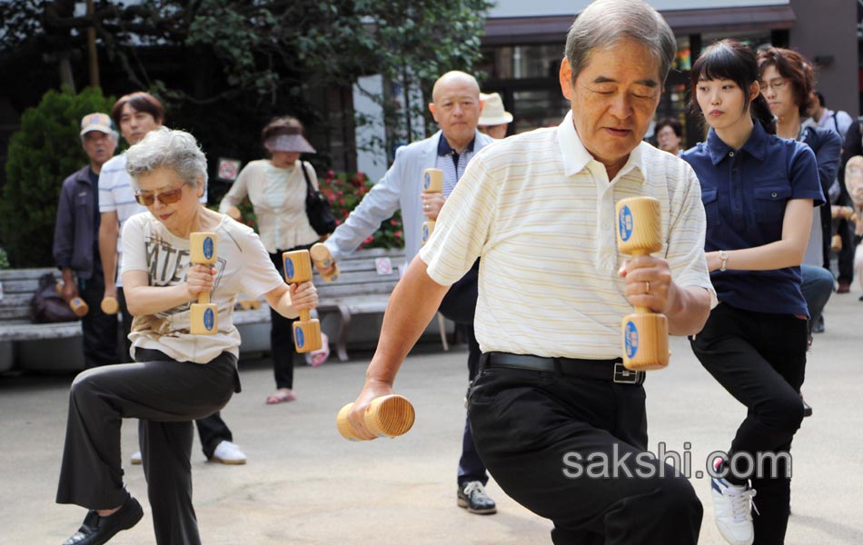 Elderly people work out with wooden dumb bells1