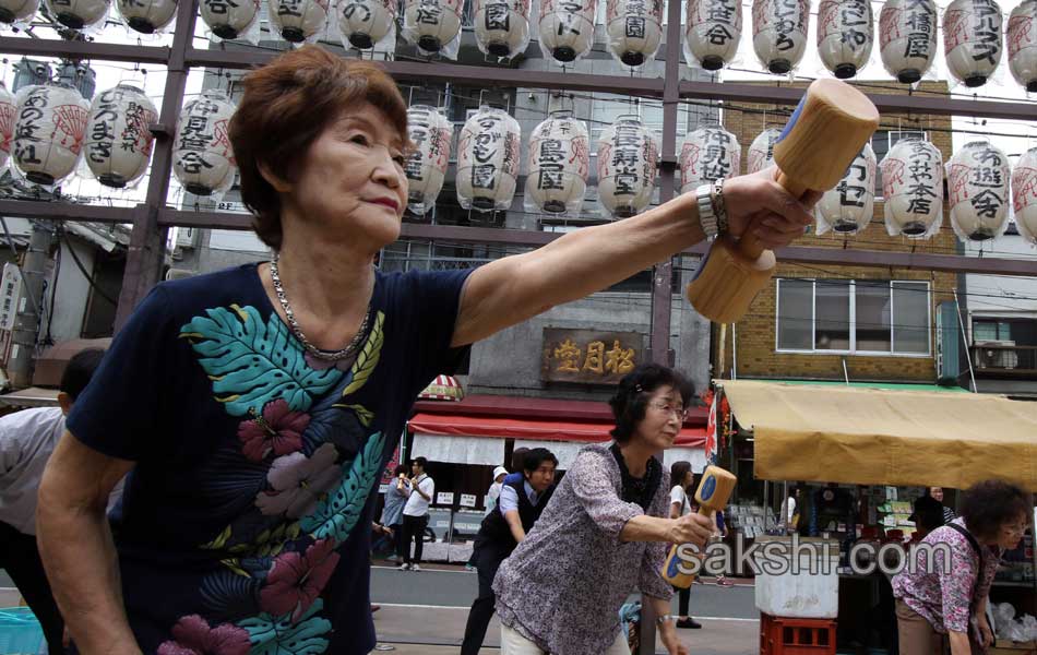 Elderly people work out with wooden dumb bells5