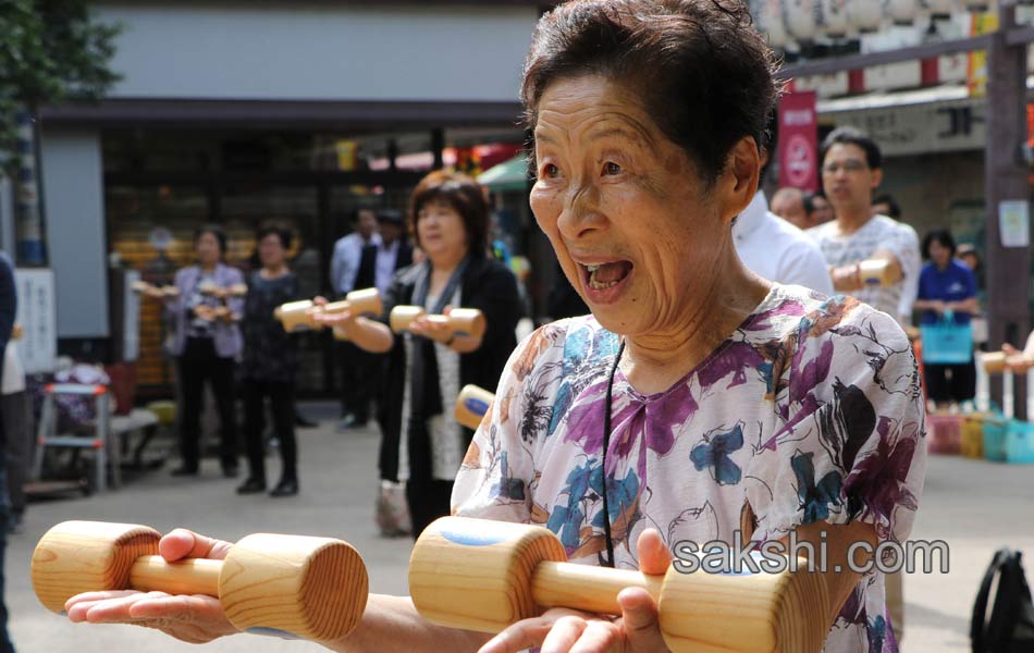 Elderly people work out with wooden dumb bells7