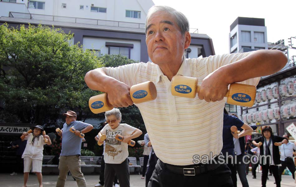 Elderly people work out with wooden dumb bells8