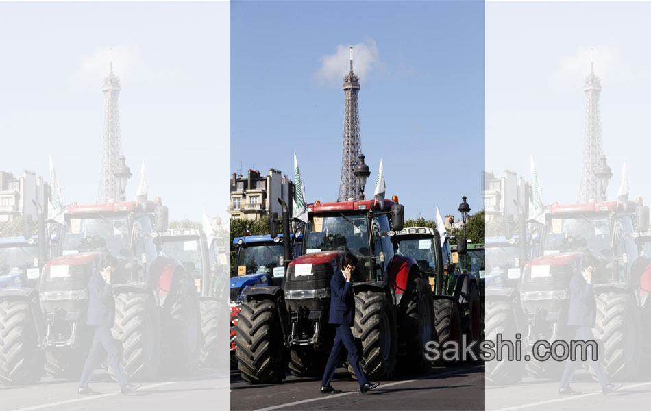 Tractors roll along a street in Paris20