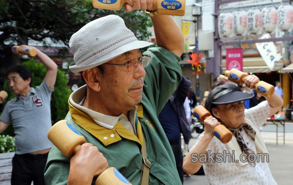 Elderly people work out with wooden dumb bells9