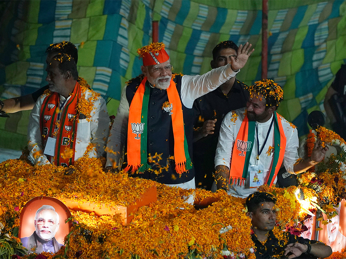 Narendra Modi greets supporters as he arrives for an election campaign rally - Sakshi1