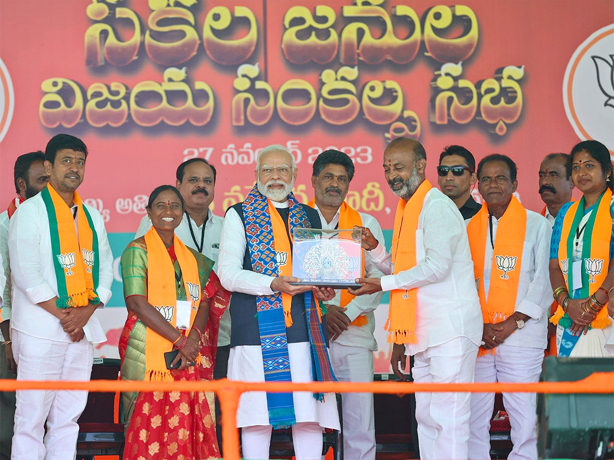 Narendra Modi greets supporters as he arrives for an election campaign rally - Sakshi11