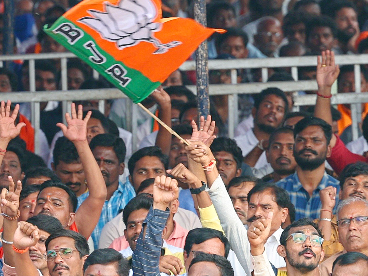 Narendra Modi greets supporters as he arrives for an election campaign rally - Sakshi13