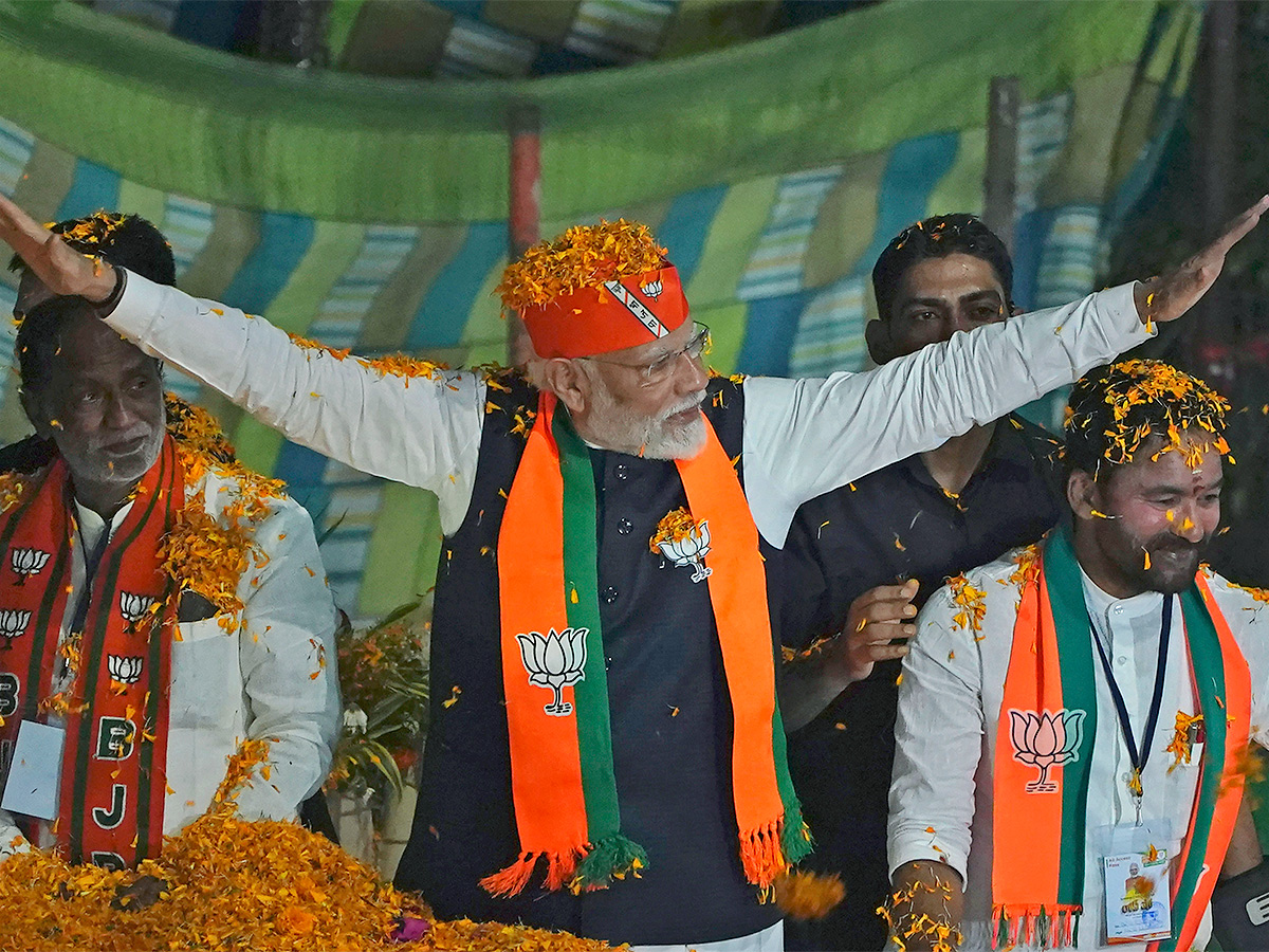 Narendra Modi greets supporters as he arrives for an election campaign rally - Sakshi15