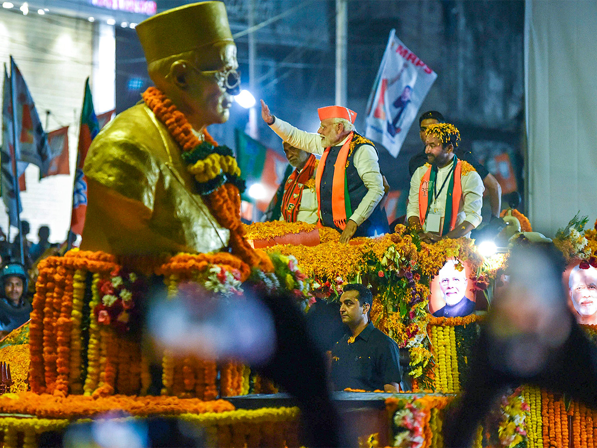 Narendra Modi greets supporters as he arrives for an election campaign rally - Sakshi2