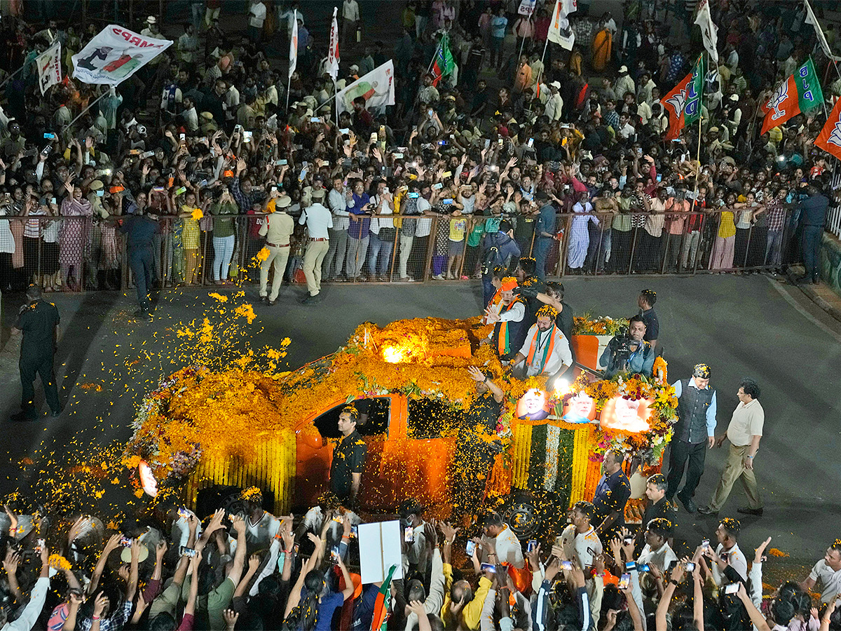 Narendra Modi greets supporters as he arrives for an election campaign rally - Sakshi23