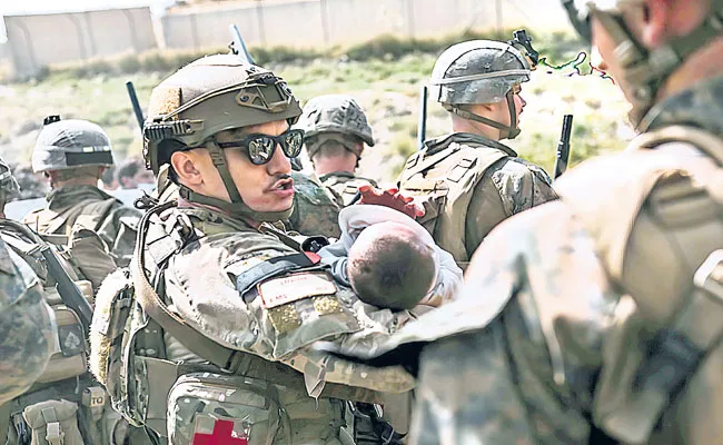 Afghan baby, handed to US troops over Kabul airport fence - Sakshi