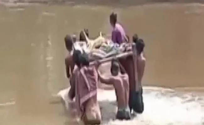 Woman Bitten By Snake Was Carried On Cot Across Waist Deep Water - Sakshi
