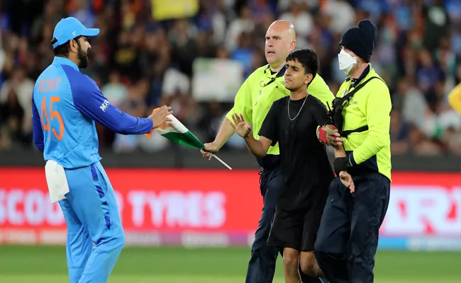 Security Arrest Pitch Invader Try To Hug Rohit Sharma IND Vs ZIM Match - Sakshi