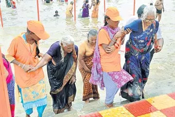 : పుష్కరస్నానం తర్వాత వృద్ధులను నదిఒడ్డుకు తీసుకొస్తున్న వలంటీర్లు