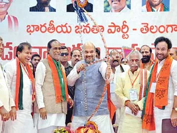 సదస్సులో విల్లు ఎక్కుపెడుతున్న బీజేపీ జాతీయ అధ్యక్షుడు అమిత్ షా. చిత్రంలో నేతలు చింతల రామచంద్రారెడ్డి, లక్ష్మణ్, దత్తాత్రేయ, కిషన్ రెడ్డి. - Sakshi