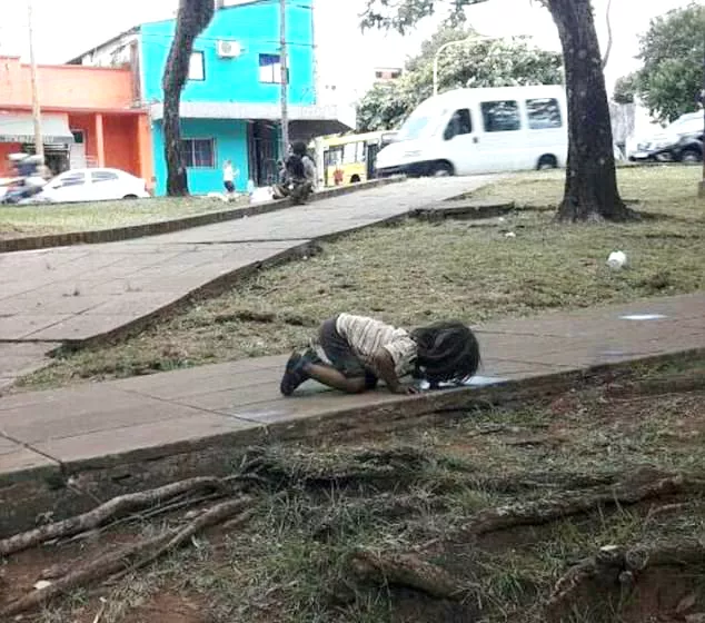 Journalist Captures Picture of Girl Drinking from Sidewalk Puddle in Argentina Heatwave - Sakshi