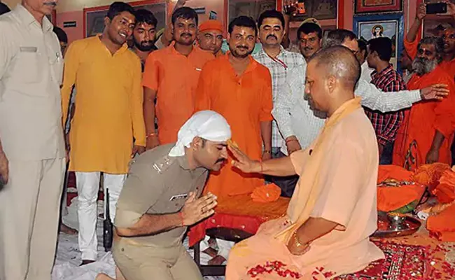 UP Cop Trolled Because Kneels Before Yogi Adityanath - Sakshi