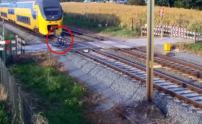 Netherland Cyclist Narrowly Escape Oncoming Train By A Split Second - Sakshi