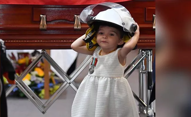 Daughter Of Firefighter Wears His Helmet At Funeral - Sakshi