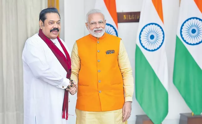 PM Narendra Modi meets Sri Lankan PM Mahinda Rajapaksa - Sakshi