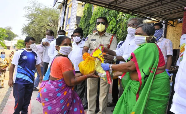 సరుకులు పంపిణీ చేస్తున్న త్రీటౌన్‌ సీఐ శ్రీధర్‌  - Sakshi