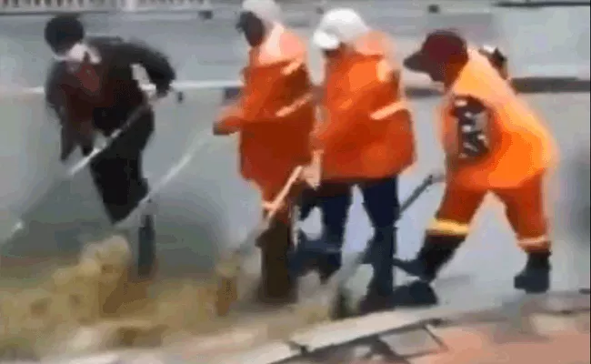 Watch Video Group Of Men Clear Street After Heavy Rains - Sakshi