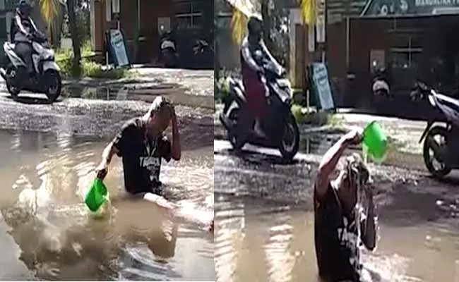 Viral Video: Indonesian Man Bathing And Fishing In Giant Pothole - Sakshi