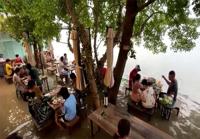 A Great Experience Thai Riverside Cafe Makes waves as flood And Taking Mouthfuls Of Food  - Sakshi