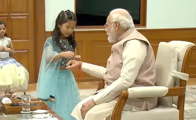 Daughters Of Staff Members Tie Rakhi To PM Narendra Modi - Sakshi