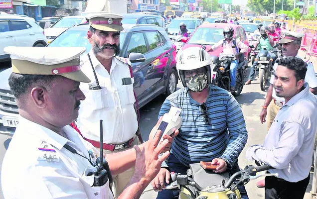 చైన్నెలో వాహనదారుడికి జరిమానా విధిస్తున్న ట్రాఫిక్‌ పోలీసులు  - Sakshi