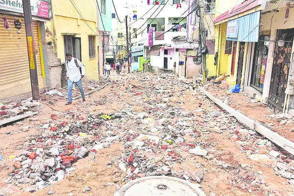 వినాయకనగర్‌లో వర్షానికి కొట్టుకుపోయిన చదును చేసిన మట్టి రోడ్డు  - Sakshi