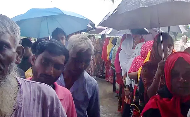 Voters Queue Up at a Polling Station in Basanti of South 24 Parganas District Amid Rainfall - Sakshi