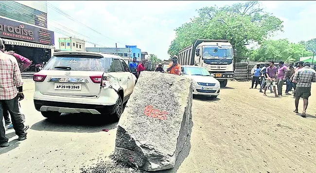 లారీ నుంచి పడిన భారీ గ్రానైట్‌ రాయి,పక్కనే దెబ్బతిన్న కారు  - Sakshi