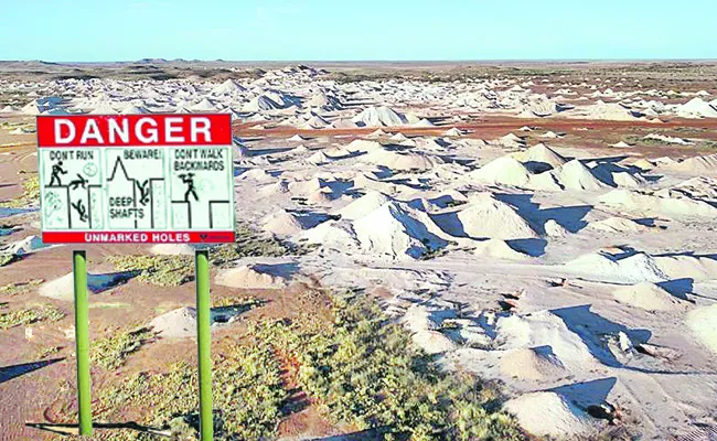 common warning sign around Coober Pedy to prevent people from falling down drilling holes or mine shafts used for opal mining - Sakshi