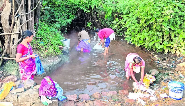 వేడినీళ్లలో దుస్తులు ఉతుకుతున్న మహిళలు - Sakshi