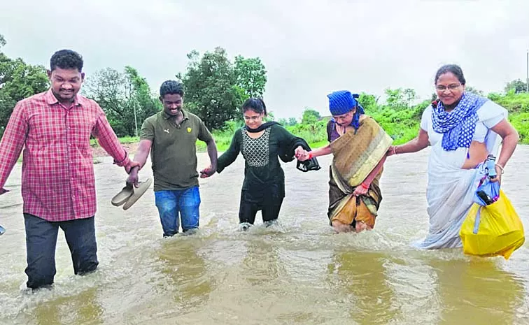 wades through stream to hand over medicines to tribals: telangana