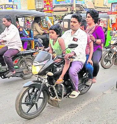 హెల్మెట్ లేకుండా పరిమితికి మించి ద్విచక్రవాహనంపై ప్రయాణిస్తున్న కుటుంబం