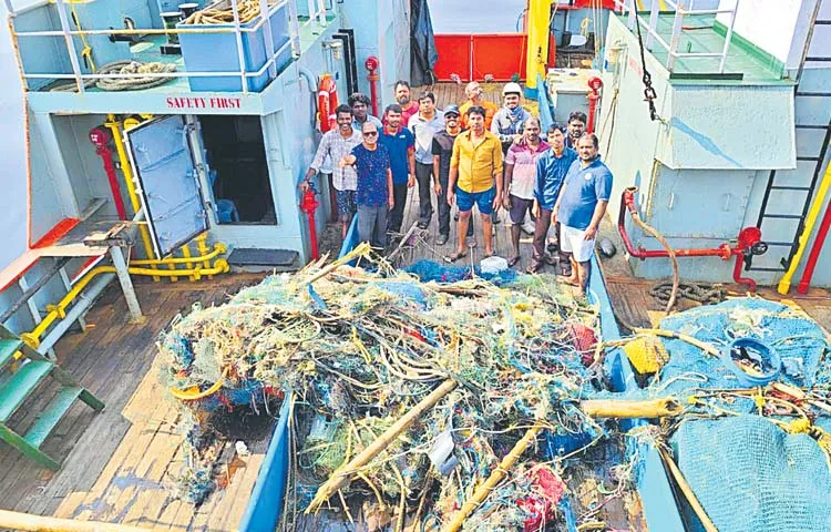 Fishermen throwing damaged nets into the sea