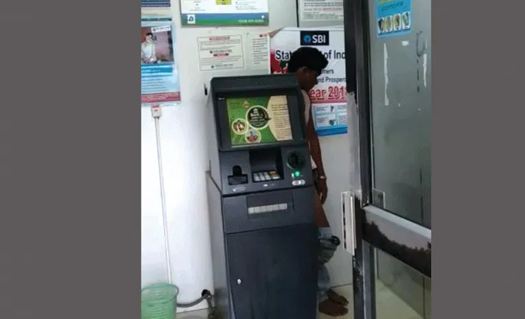 man urinating inside the ATM