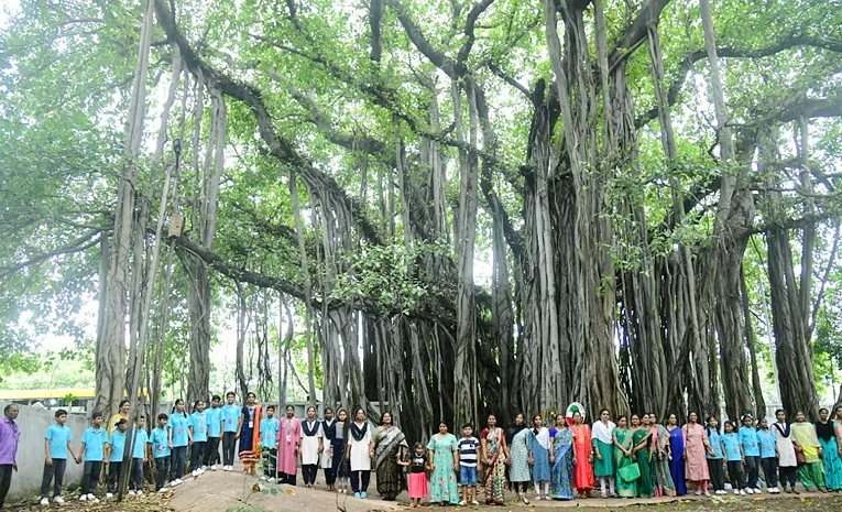 Students tie Rakhi to hundred years of history old banyan tree in Visakhapatnam Photos